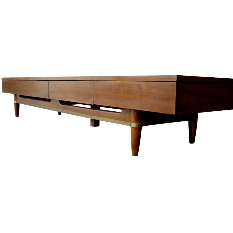 A mid century modern coffee table or bench from American of Martinsville's Dania Collection.  Mahogany with three drawers and brass decorative element on the base.