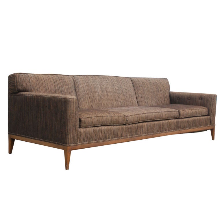 A mid century modern sofa made by Drexel.  Its slightly curved form gives it unusual aesthetic appeal.  Walnut base with original variegated brown upholstery.