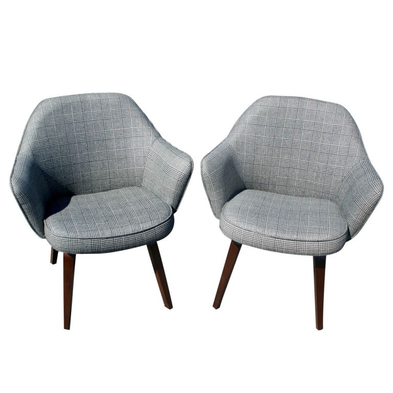 A pair of mid century modern armchairs designed by Eero Saarinen and made by Knoll. These are rarer early edition chairs with wooden legs, newly upholstered in a houndstooth fabric. As shown in the last image, we have a matching pair of early