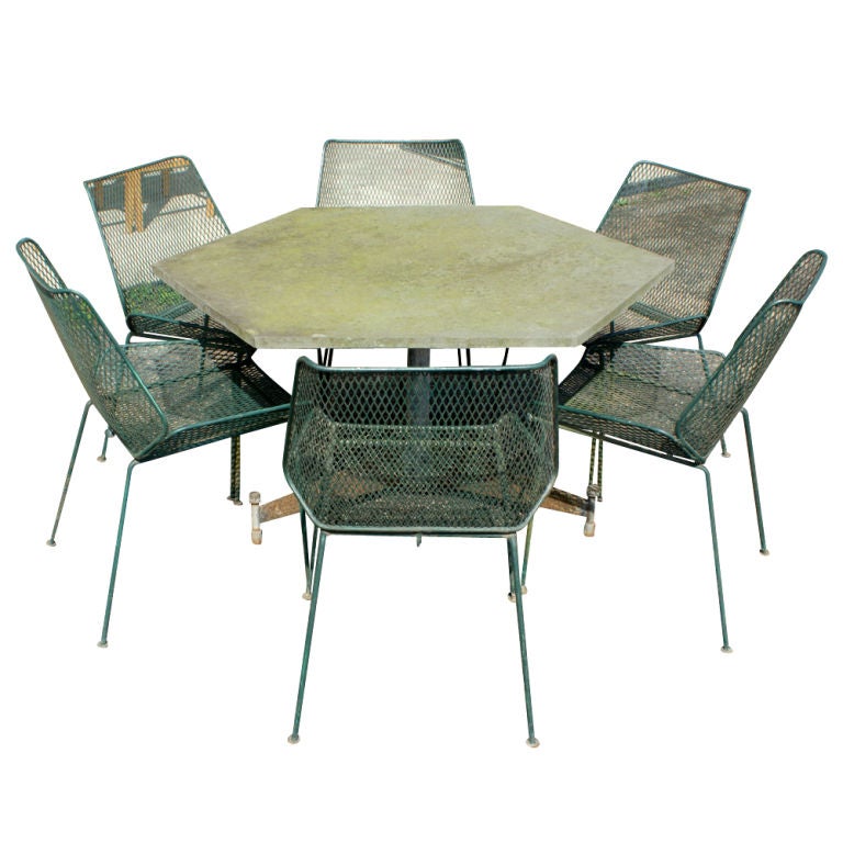 A mid century modern outdoor dining table made by Salterini with a green hexagonal slate top.