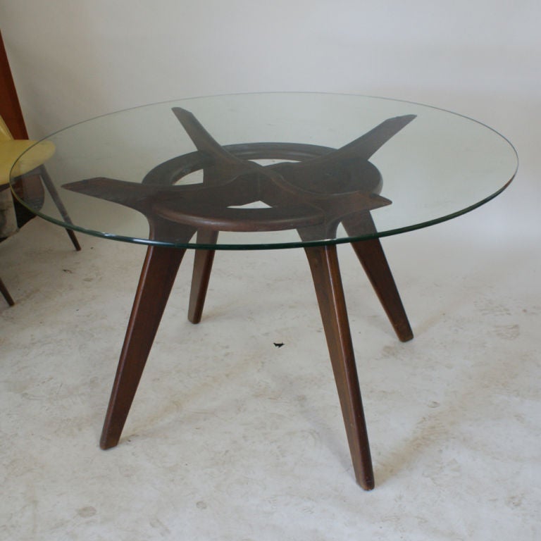 A suite of mid century modern dining furniture consisting of a table and five chairs designed by Adrian Pearsall and made by Craft Associates.  The table with a sculpted walnut base and glass top.  The chairs with walnut bases and muted yellow