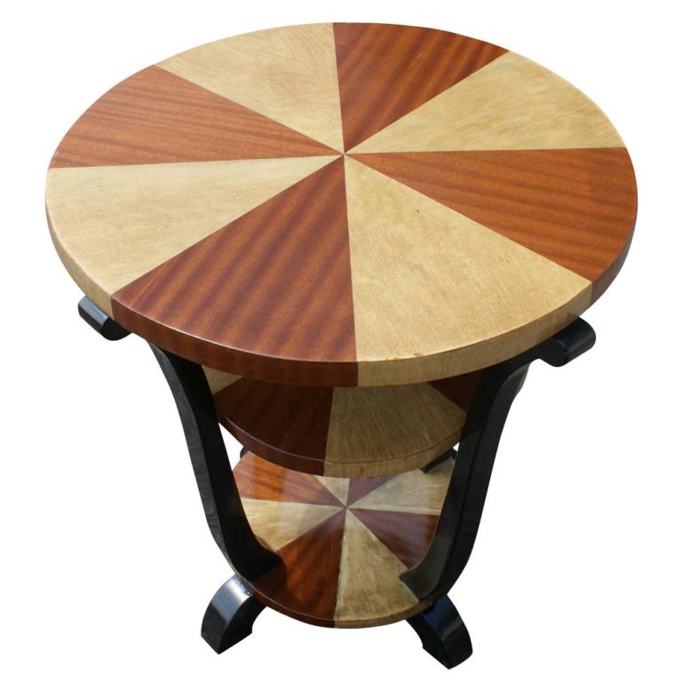 An Art Deco style side or lamp table possibly from France. Triple tiered round surfaces of radiating mahogany veneer alternately stained and bleached. Ebonized supports and feet.