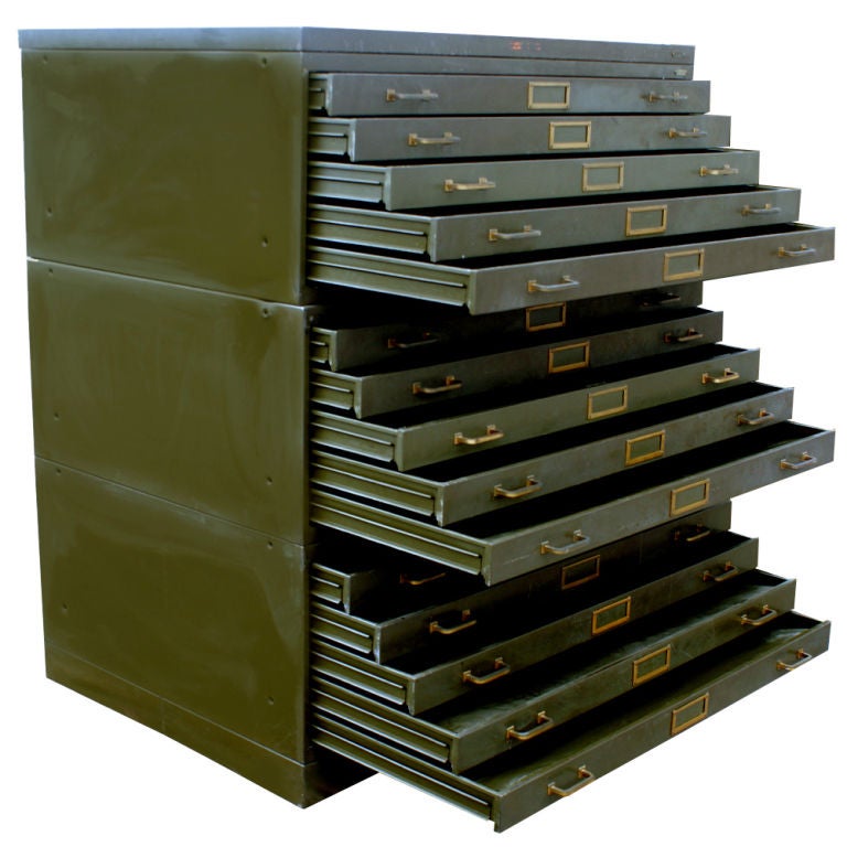 A large, industrial flat file cabinet.  Olive drab painted steel with brass hardware.  A base, three sections with five drawers each, and a top.  Each drawer measures 43