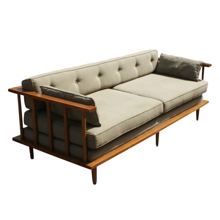 A mid century modern sofa or daybed designed by Paul McCobb.  Teak frame with platform base, spindle supports, and wraparound arms.  Light sage green detachable cushions.