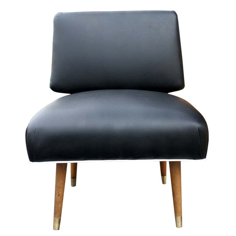 A mid century modern lounge chair showing the classic lines of Italian post-war design.  Black vinyl upholstery with white welting and wooden legs with brass sabots.
