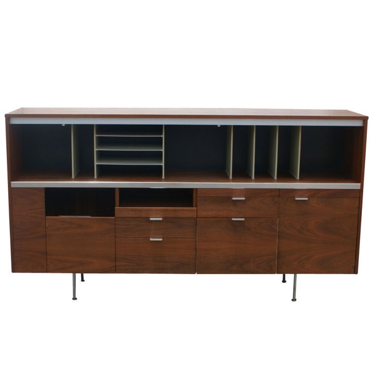 A mid century modern desk and credenza designed by George Nelson and made by Herman Miller.  The walnut credenza with multiple drawers and compartments for storage.  The desk with walnut modesty panel and laminate top measures 65