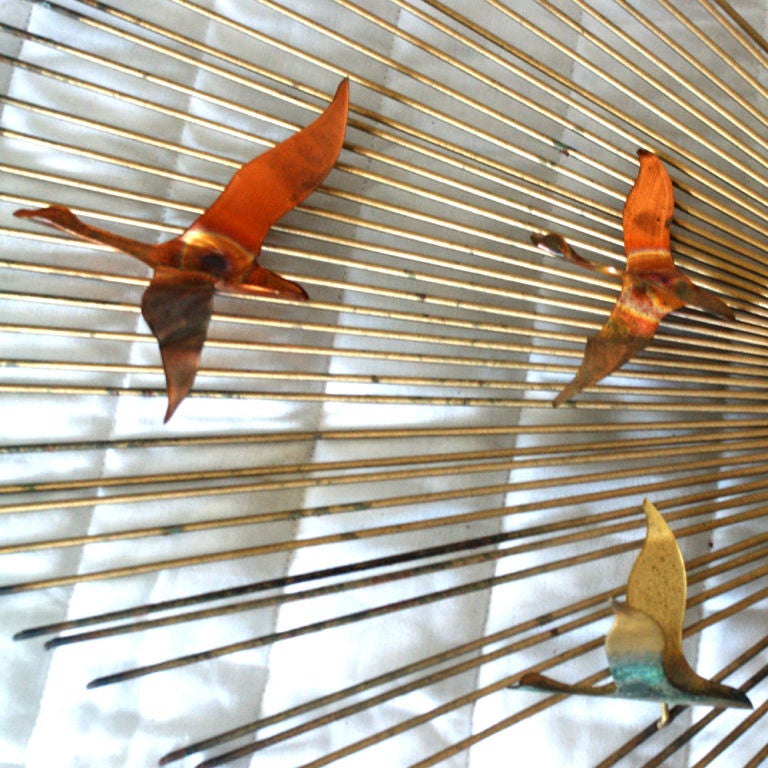 A mid century modern brass wall sculpture from Curtis Jere featuring multi-color birds in flight.