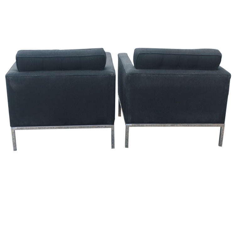A pair of mid century modern lounge chairs designed by Florence Knoll and made by Knoll.  Polished chrome frame with original black fabric upholstery.