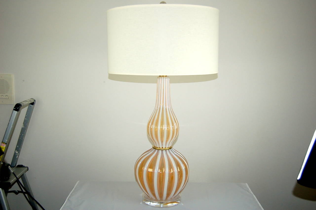 A very striking and elegant Murano lamp. The heavily defined ribbing provides a two-toned PEACHES & CREAM color. Occasionally a lamp is large and dramatic, enough that a pair would be superfluous. This is that lamp.

It stands 31 inches from