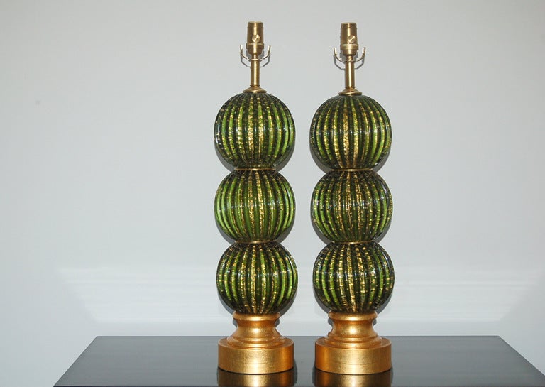 These EMERALD GREEN stacked ball Murano Lamps are Hollywood Regency at it's best. Each ball is chock full of controlled bubbles and 24 Kt. gold.

The lamps measure 25 inches from tabletop to socket top.  As shown, the top of shade is 31 inches