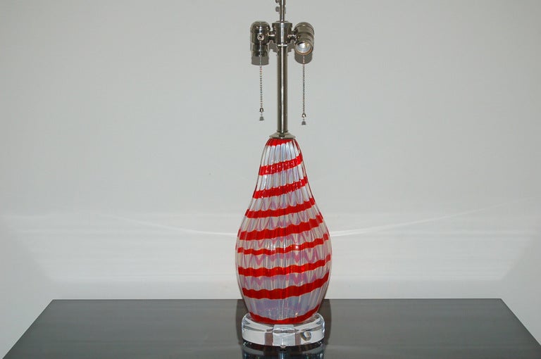 These opaline Murano glass lamps were blown in the 1960's. They have a whimsical Anzola Fuga flavor to them. The opaline glass has bright CHERRY RED ribbons that swirl in a circular ascending pattern.

The lamps measure 23 inches to the top of the