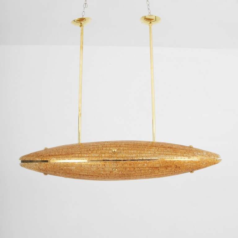 Two enormous pieces of GOLDEN Pulegoso-like glass, in clam shell configuration, hanging from brass rods.  The glass work is exquisite - heavily textured and ribbed. An interior frame accommodates 16 lights.

Each glass piece measures 54 inches