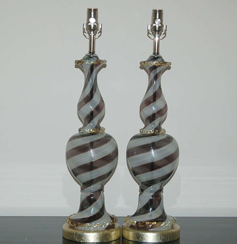 Classically elegant vintage Murano lamps by Dino Martens for Aureliano Toso.  Each body is made of two pieces of filigrana striped glass in BLACK, WHITE, AND COPPER - an elegant BLACK TIE style.

The lamps stand 28 inches from tabletop to socket