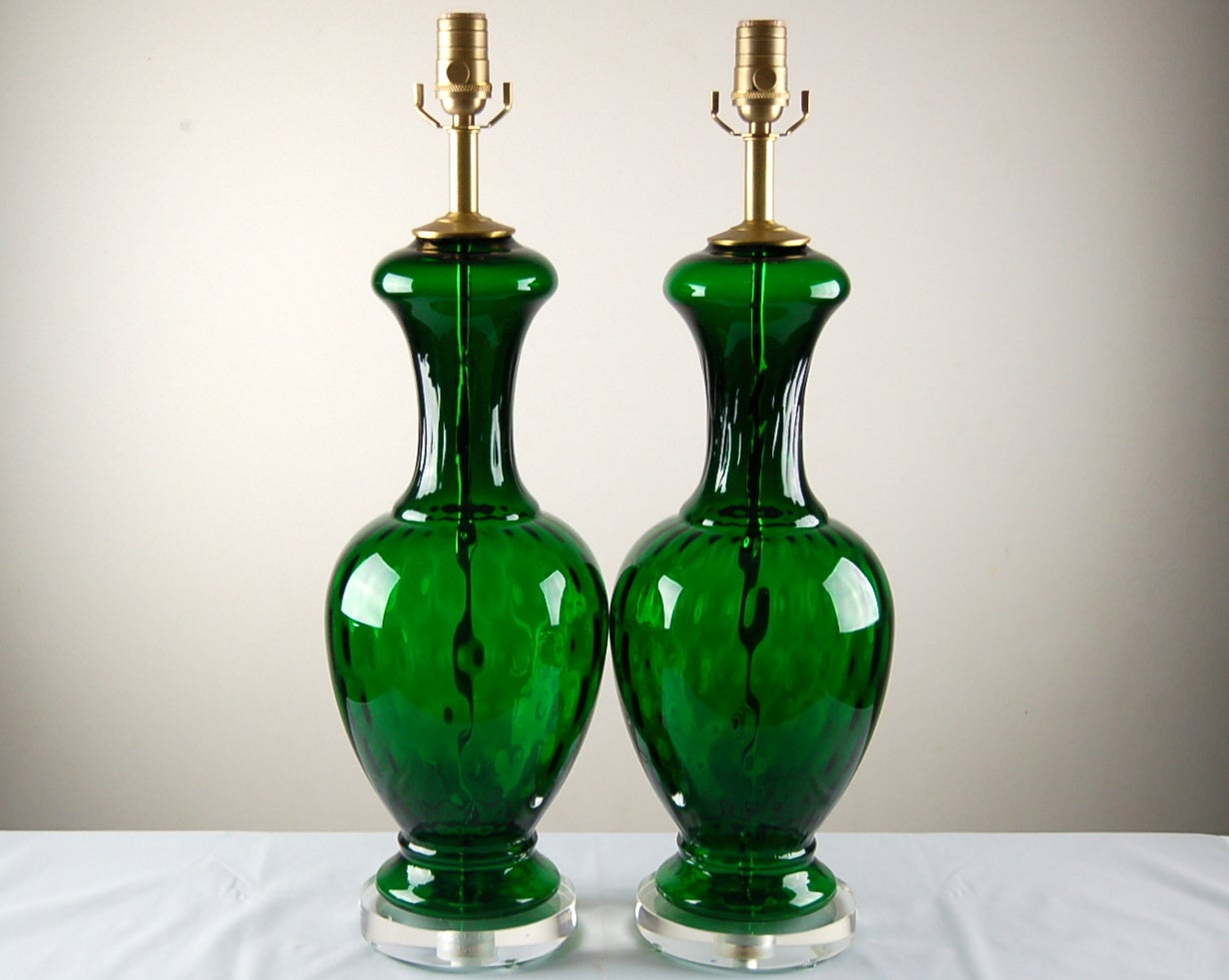 Very vibrant emerald-green vintage Murano lamps with a visual surprise. Though smooth to the touch, these lamps look multifaceted, courtesy of the optics, (see pictures 8-10).

They Stand 25 inches from tabletop to socket top. As shown, the top of