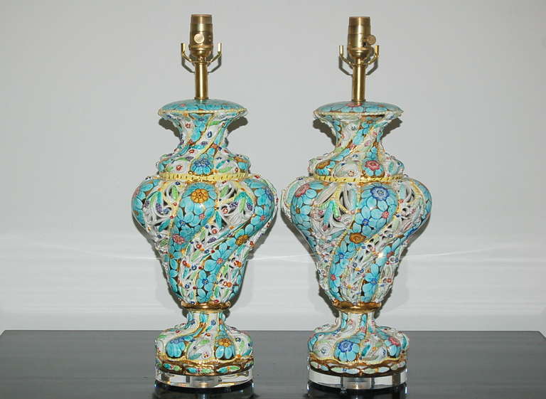 Matched pair of vintage Capodimonte table lamps, each signed, as shown. Capodimonte's trademark is the bright colored glazes they used, and these lamps are cheerfully bright and impressive. Hand painted gold accents. 

The lamps stand 22 inches