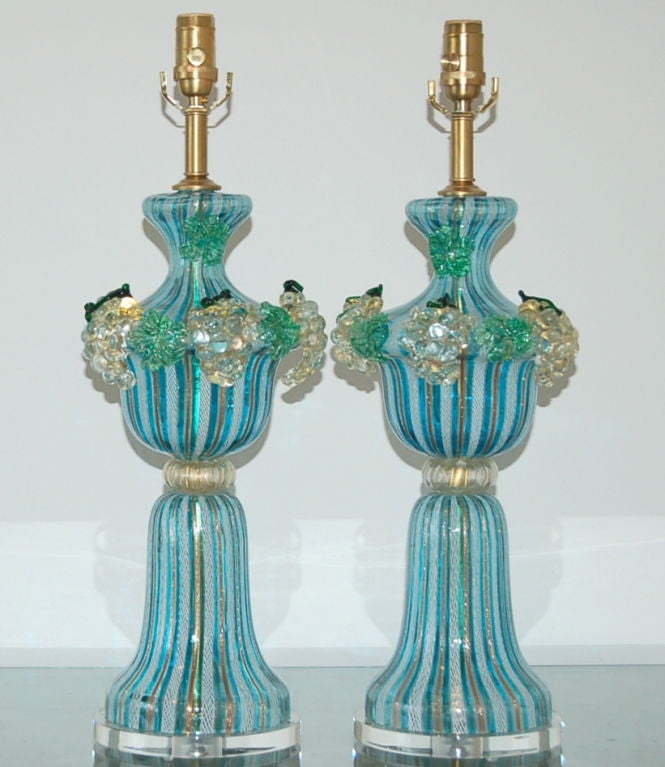 Matched pair of vintage Murano table lamps by Dino Martens. The fruit spilling over the top is intricately done, and in perfect condition. The striped lamp bodies of TURQUOISE, COPPER, and white are joined together by a glazed donut of GOLD filled