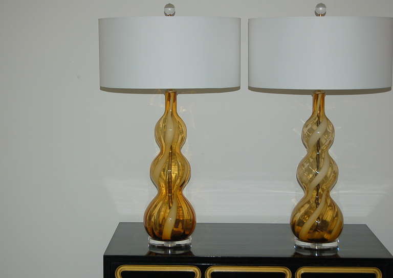 A thick ribbon of white winds up and around these BUTTERSCOTCH tri-levels.  The color is intense, but there is a slight shade variance between the two lamps, as we've shown through our pictures. 

The lamps stand 27 inches from tabletop to socket
