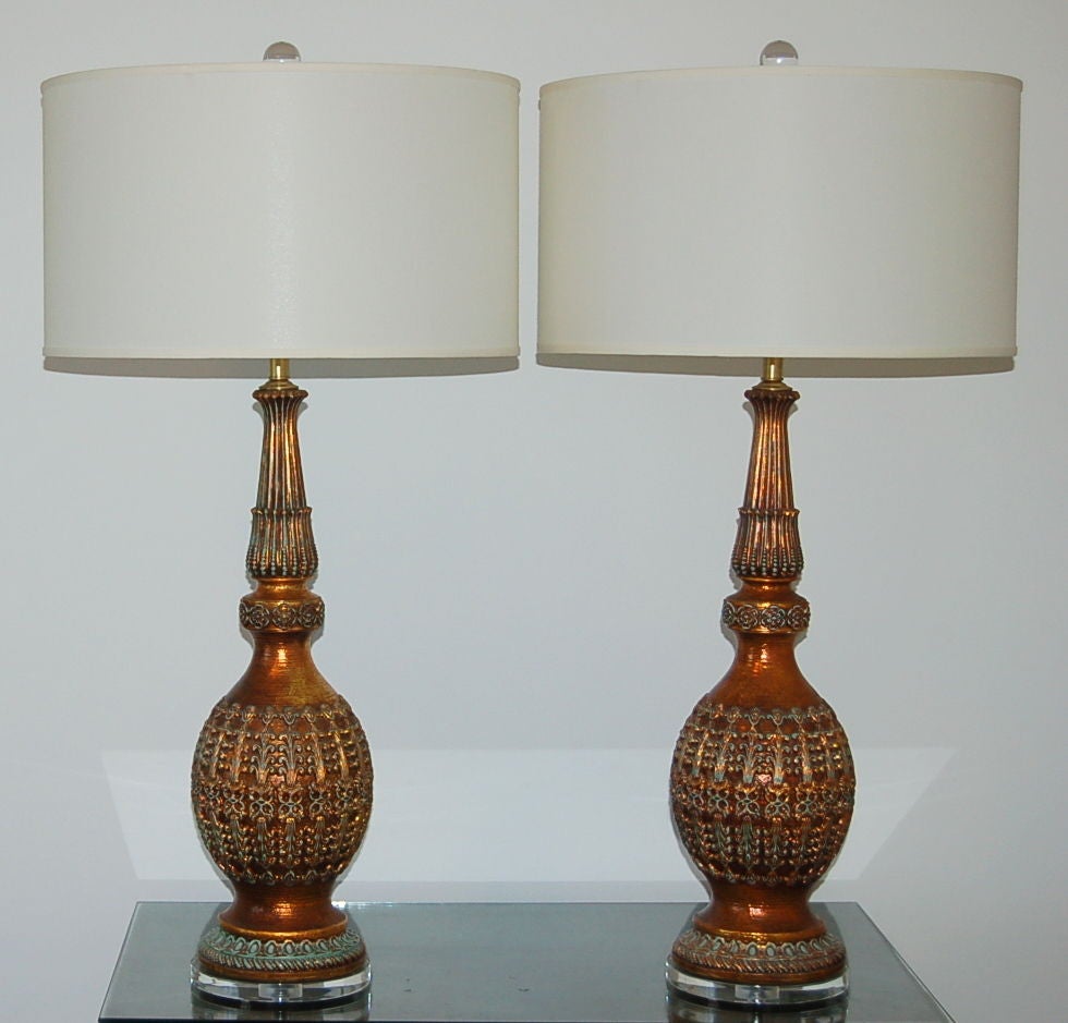 A very stylish pair of ceramic lamps with Moroccan flair.  These lamps have intricately carved detail with great texture and color!<br />
<br />
We show these on wafer thin Lucite.  They have been rewired with all new solid brass hardware and are