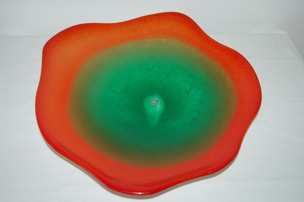 This free-form plate was imported from the Island of Murano in the late 1960s. Vibrant red orange surrounding variations of Kelly Green for an accent piece certain to grab attention.

The plate is about 19 inches across and 3 inches in height. 