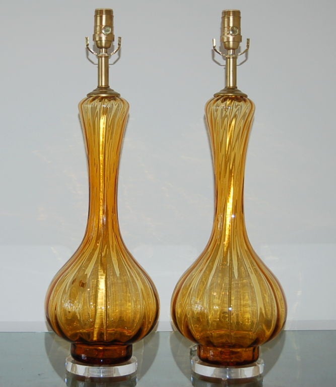 These beautiful vintage Murano lamps are a rich GOLDEN HONEY.  They are wonderfully curvaceous and have ribbed vertical swirls in the glass.  

They stand 25 inches to the top of the socket.  As shown, the top of the shade is 32 inches high. 