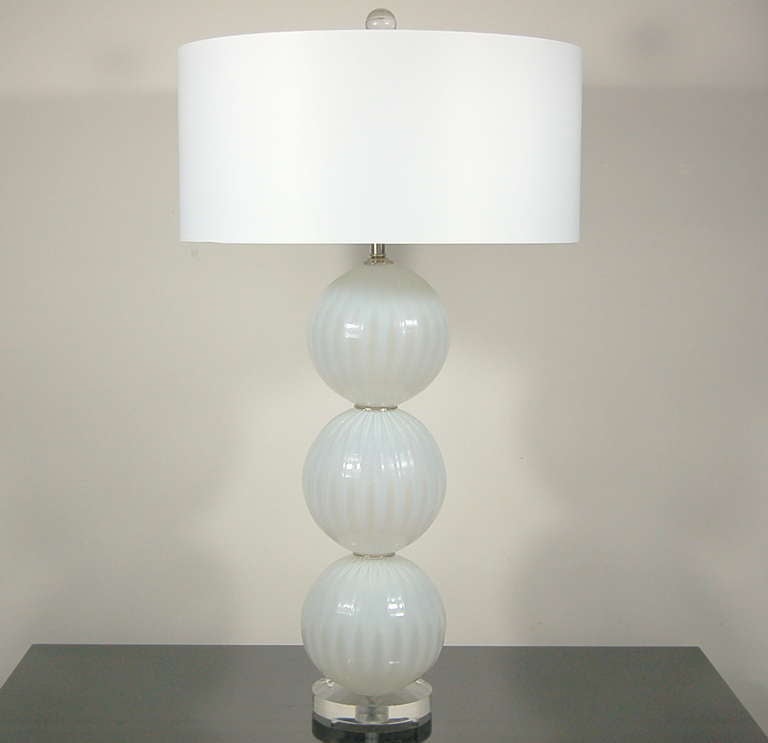 Matched pair of handblown three-ball glass lamps by Joe Cariati in OYSTER OPALINE. Vertical ribs add optical and dimension - a very elegant pair of lamps.

They stand 28 inches to the top of the socket. As shown, the top of shade is 34 inches high.