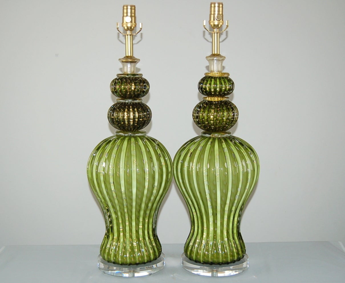 Matched pair of vintage Murano table lamps in a spectacular combination of Hollywood Regency glamour and Barovier & Toso style. Each MOSSY GREEN lamp is filled with controlled bubbles rimmed in GOLD. A very elegant and rare pair!

They stand 27