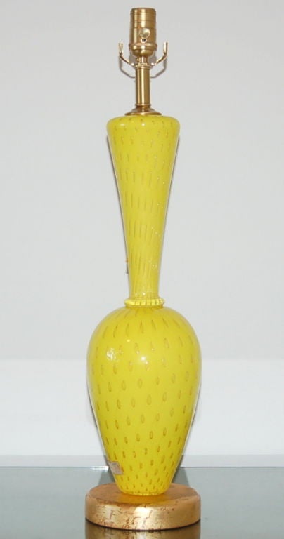 This CANARY YELLOW Murano lamp is filled with controlled bubbles and 24-karat gold. Check out the incredible pattern of gold bubbles in the close up photo - it's hard to believe this glass was handmade. 

The lamp stands 26.5 inches to the socket