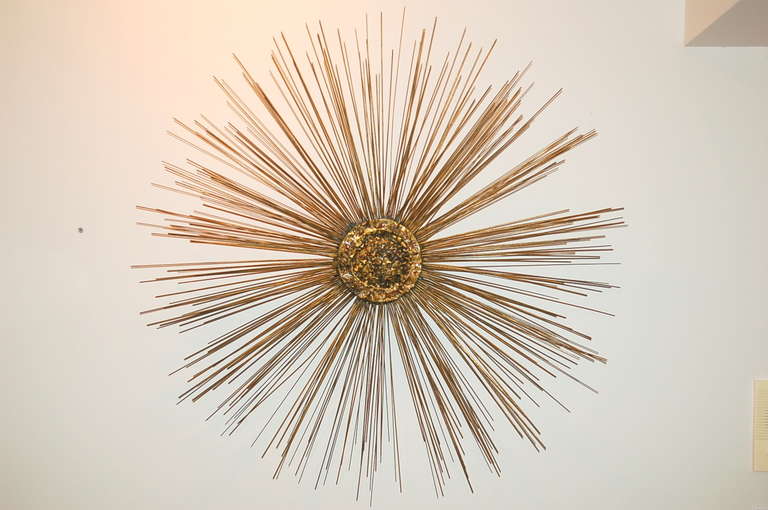 A gorgeous brass wall sculpted sunburst by Curtis Jere. Wonderfully patinated brass spokes surround a 7 inch brased hub. 

This sculpture is 41 inches across, 3 inches deep, and weighs about 15 pounds.