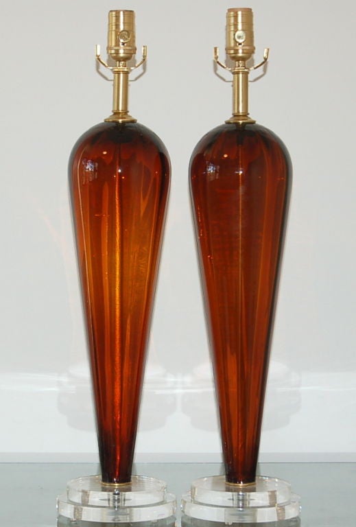 I love the simplicity of these COGNAC colored Murano glass teardrops. They have a broad shouldered, cinch waisted silhouette. We show them mounted on double discs of Lucite complemented by brushed brass. 

The lamps are 25 inches from tabletop to