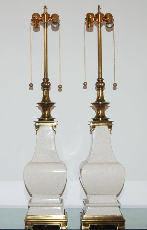 Stylish sculpted White ceramic lamps by Stiffel with craquelure. We have eliminated the outdated glass globes and replaced them with sockets operated by earring pulls.

These lamps stand 38 inches from tabletop to socket top. As shown, top of the