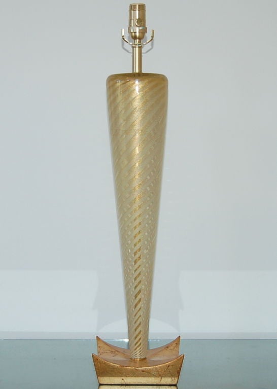 Diagonal ascending stripes of gold and vanilla are wrapped up and around this chunk of glass in Sommerso style, all sprinkled liberally with 24-karat gold dust.

The lamp stands a whopping 29 inches to the top of the socket - the glass piece alone