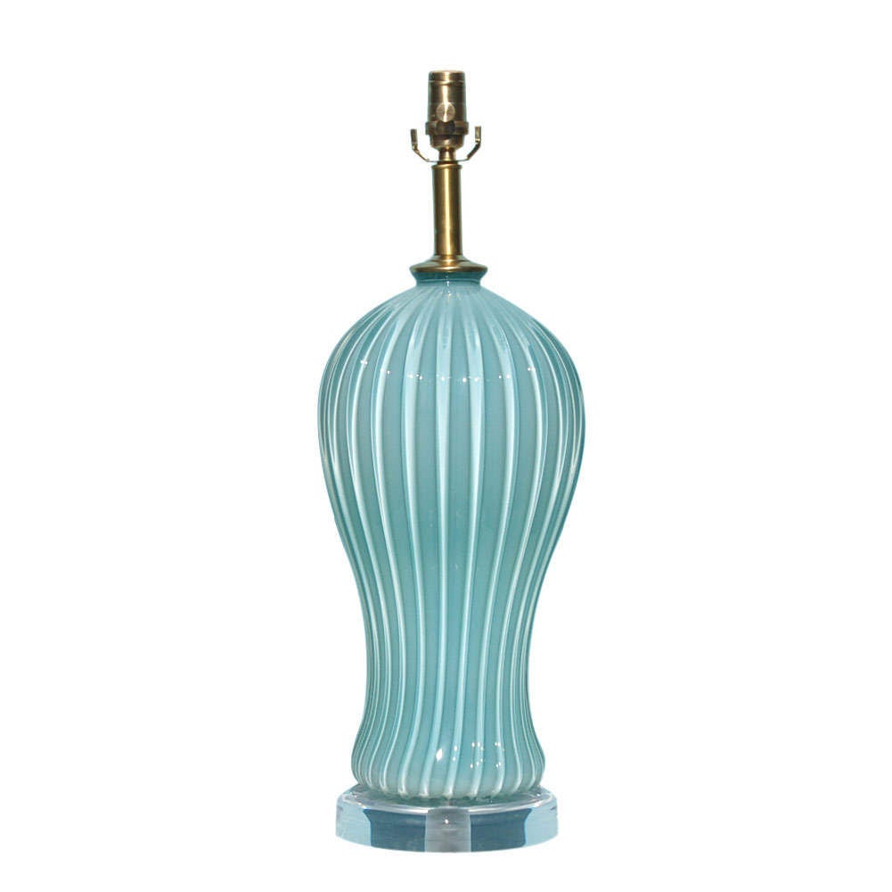This elegant Sky Blue opaline glass lamp was blown by Seguso, circa 1964.  The glass is massive - we show it mounted on a Lucite chunk.  The hardware is solid brass in a satin finish - so elegant against this lovely blue color.

The lamp measures
