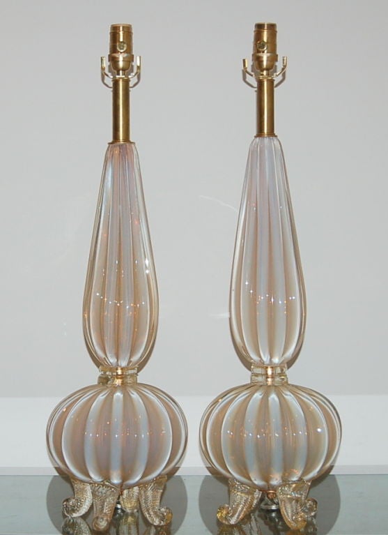Spectacular pair of rare SOFT PEACH Opaline lamps blown by Archimede Seguso in the mid 1950s.  Classic four footed design  with strong vertical ribs.  The waistband and feet have 24KT gold flake blown into the glass.  

These lamps have been