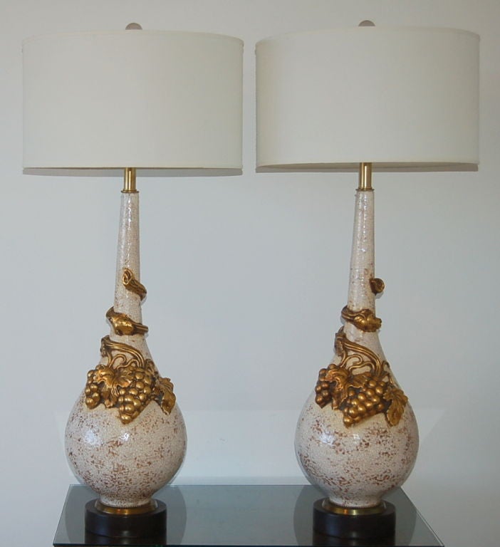 Monumental ceramic table lamp sculptures by Nardini Studios of California, circa 1960.  The bodies are WHITE CRAQUELEUR with GOLD grapevines winding up and around.  This beautiful matched pair came to us from their original owner.

The lamps