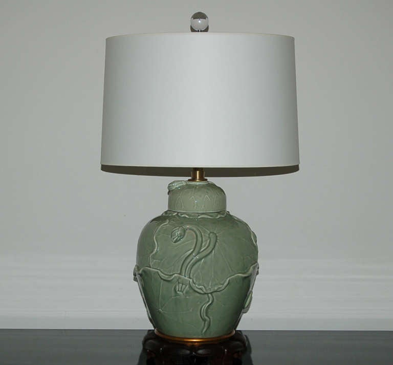 Hard to find matched pair of CELADON lamps by The Marbro Lamp Company.  Applied floral vines crawl up and around each urn and lid.  Based on footed, carved rosewood lotus bases.

They stand 24 inches from tabletop to top of socket. As shown the