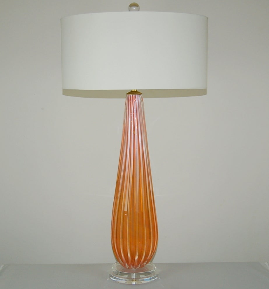 These statuesque Seguso lamps are MELON ORANGE, with an ethereal glow to the glass, courtesy of the opaline. This matched pair has unique swirls in the color, as shown in our pictures.  

They stand 31 inches from tabletop to socket top. As shown,