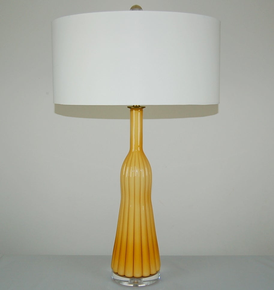 Matched pair of vintage Murano table lamps. Stylish tassel-shaped Murano lamps with deeply defined ribs. The white cased glass inner core gives these lamps a CREAMY BUTTERSCOTCH yellow color. 

They stand 27 inches from tabletop to socket top. As
