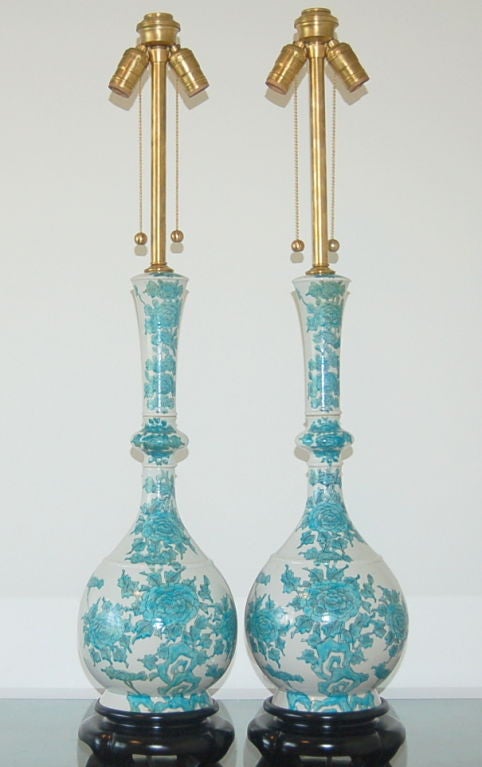 Monumental matched pair of porcelain lamps imported from Japan by The Marbro Lamp Company, circa 1969.  The two piece lamps have an intricate floral pattern in BLUE GREEN and look divine on their original black lacquer bases.

The lamps measure 40