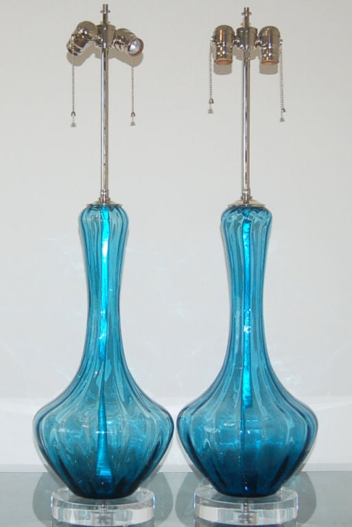 A spectacular pair of TEAL BLUE Murano lamps with vertical optics.  The color of the glass makes these lamps so special!  We show them on chunky Lucite paired with nickel hardware.  <br />
<br />
The lamps stand 27 inches from tabletop to socket
