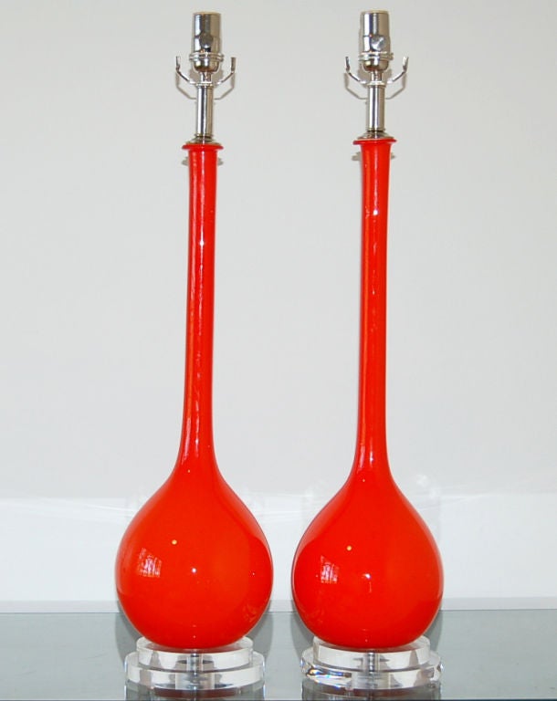 Vintage pair of Murano Long Neck table lamps by Archimede Seguso, imported in the 1960s. A layer of white cased glass at the core is surrounded by a thick layer of VERMILLION colored glass. 

The lamps are 28.5 inches tall from tabletop to socket