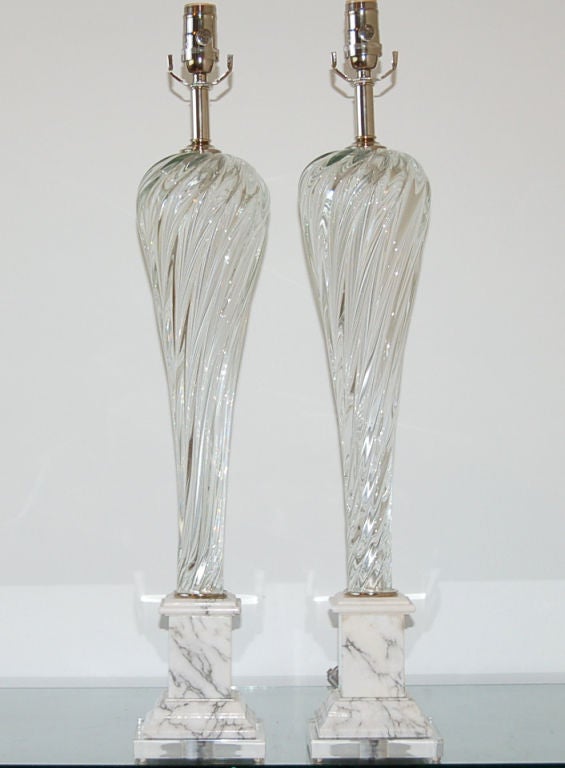 This elegant pair of vintage Murano lamps are of CRYSTAL CLEAR glass.  The thick ribs swirl diagonally up and around the glass body.  The way each stands on the Carrera marble base suggests a dancer en pointe - truly a beautiful silhouette.

The