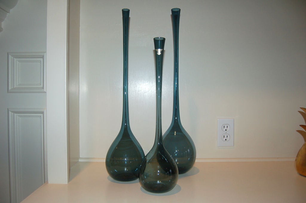 A matching set of three bottle vases designed by artist Arthur Percy for Gullaskruf Glass, 1951.  Hand blown Swedish glass of TEAL BLUE - a very elegant, special collection!

One vase has the Gullaskruf foil label.  Tallest vase is 21