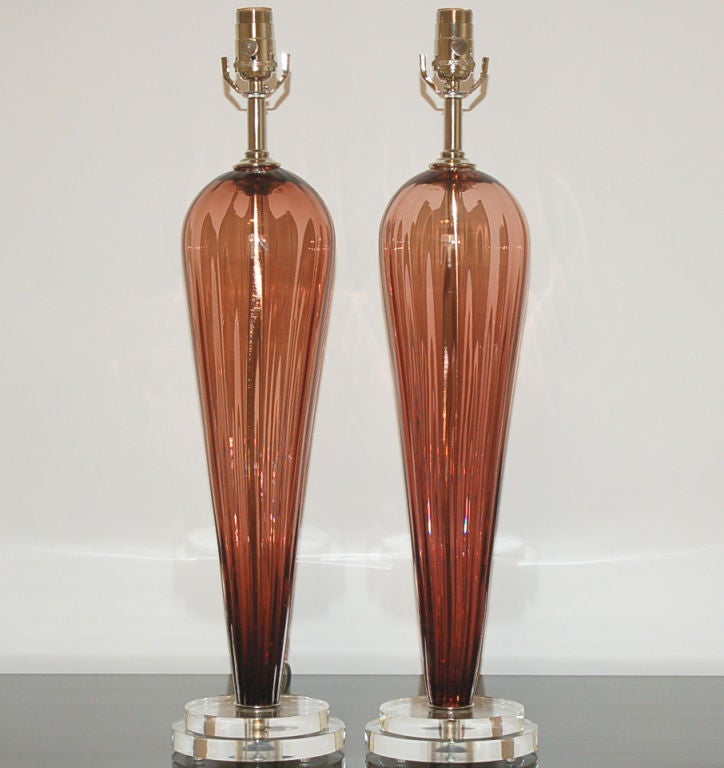 These WINE teardrop lamps are from the second edition of Joe Cariati lamps, blown exclusively from Swank Lighting. Each pair is signed by the artist.
The vertical ribs add optical treats and texture. 

The lamps measure 24 inches from tabletop to