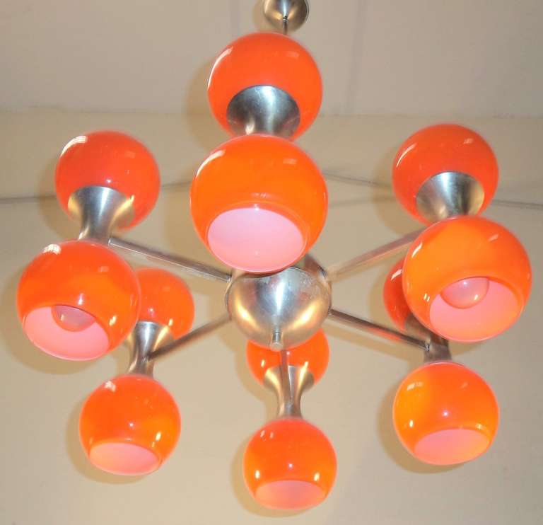 Very cool 6 arm chandelier, circa 1967. The twelve globes of Murano glass are a vibrant SODA POP ORANGE over a layer of white cased glass.  Each arm carries two lighted globes. 

Each globe is 5 inches wide and 4 inches tall. The chandelier is 20