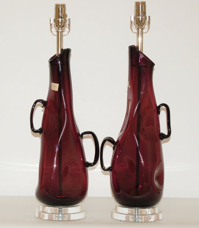 Whimsical dimpled glass lamps with handles - very sculptural. They are DEEP AUBERGINE in a wild free-form shape.  Take a close look and you'll see large, almond shaped bubbles.

The lamps are 24 inches from table top to socket top. As shown, the