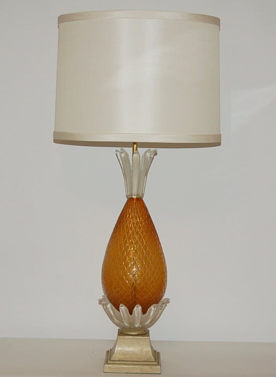 A spectacular and rare lamp, destined to be the focal point of your room. Beautiful butterscotch opaline vintage Murano glass blown as a pineapple, mounted on a wooden plinth of French Provincial style.

The lamp measures 33 inches from tabletop