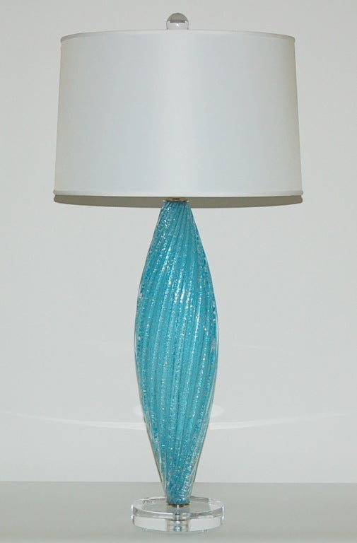 Matched pair of spectacular AQUA BLUE vintage Murano table lamps full of tiny little bubbles, in a flat oval shape. Mounted on a chunky Lucite base, with nickel-plated hardware.

These lamps are 27 inches high from tabletop to socket top. As shown,