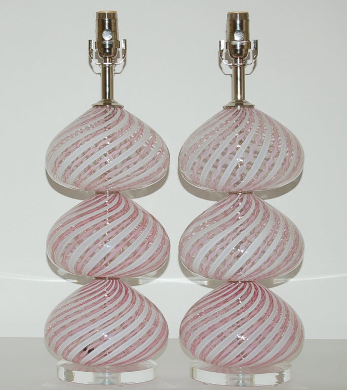 A pair of vintage Murano lamps by Dino Martens for Aurileano Toso.  Diagonal canes of PALE PINK and WHITE mounted on thin wafers of Lucite, dressed with nickel plated brass hardware

These lamps measure 22.5 inches from tabletop to socket top. As