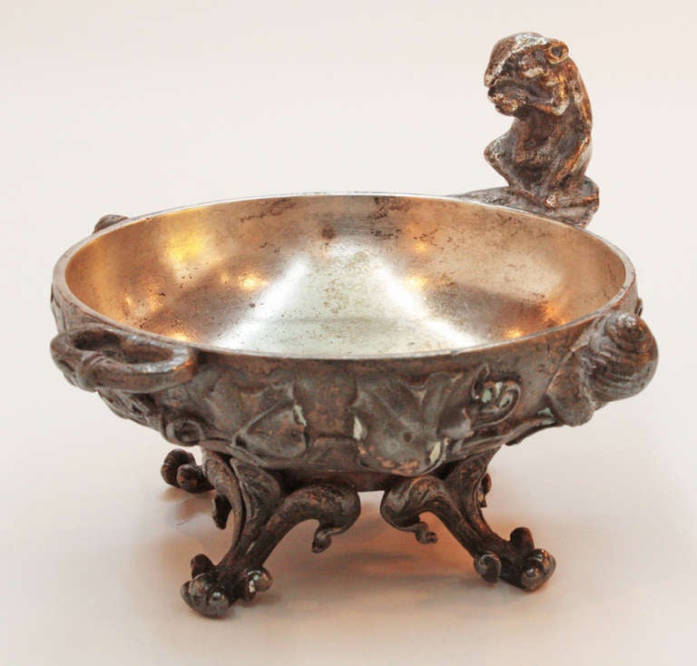 a small dish with heavily repousse'd floral and leaved decoration on sides and carved fleur de lis feet and figural mouse overlooking the edge, signed CAIN (Auguste, 1822-1894)