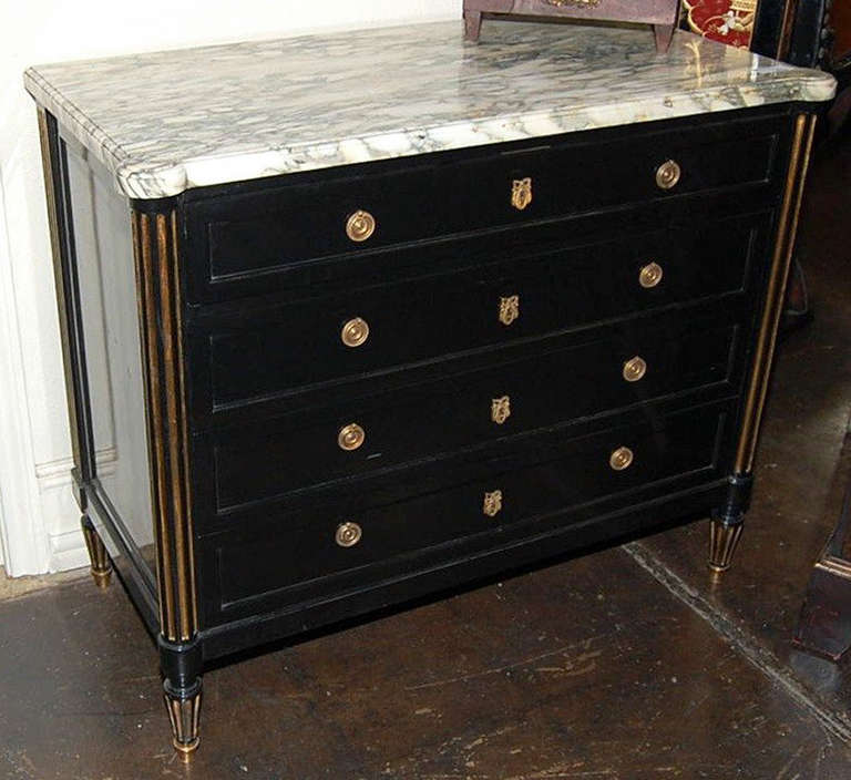 a sensational French black lacquered Jansen commode featuring gold tapered sides with four locking drawers and topped with an amazing white grey veined marble

stamped JANSEN